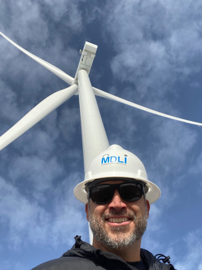 MDLI renewables team member on site at a wind turbine